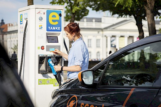 Frau tankt Carsharing Elektroauto
