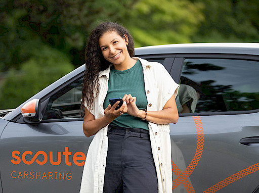 Junge Frau steht vor Carsharing Auto