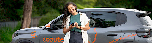 Junge Frau steht vor Carsharing Auto