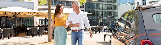 Mann und Frau neben Carsharing Auto