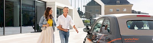 Mann und Frau neben Carsharing Auto