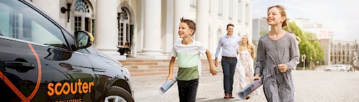 Familie läuft zu Carsharing Auto